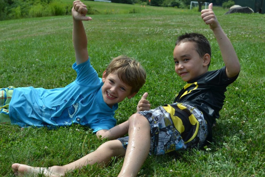 Two boys from a Christian school laying in the grass.