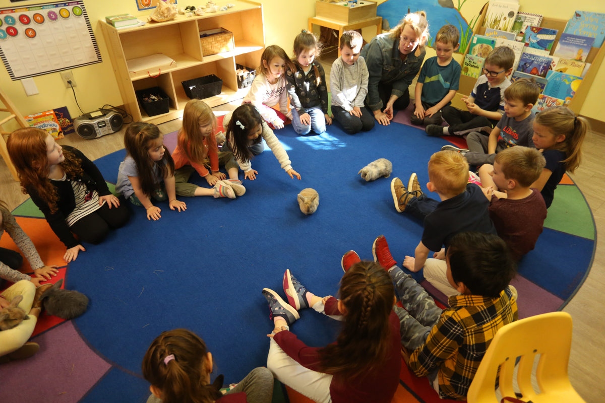 A group of children sitting in a circle in a Christian school classroom.