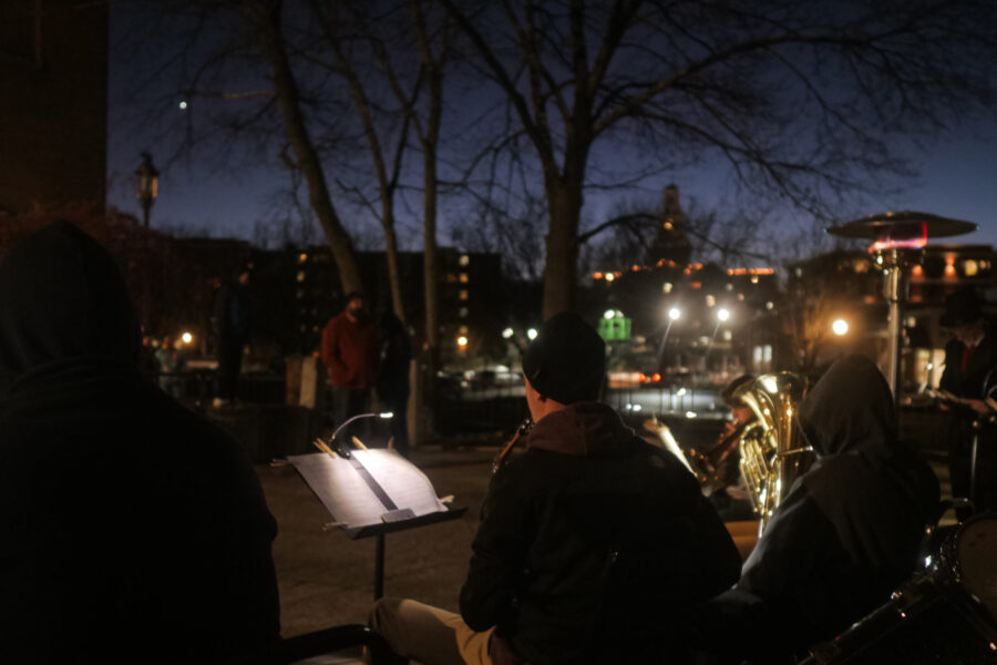 A group of people from a Christian school playing instruments in a park at night.