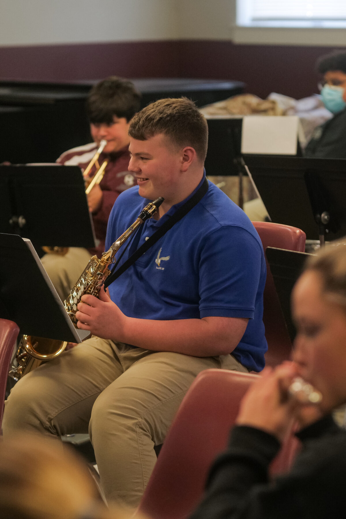 A group of students playing saxophones in a Christian school classroom.