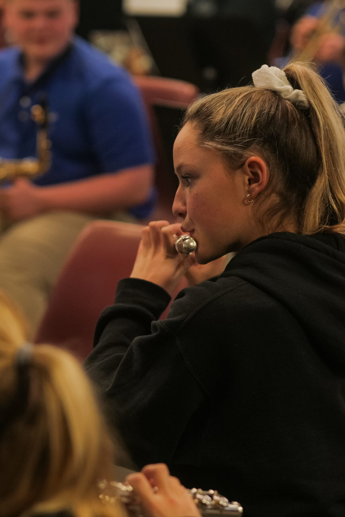 In a Christian school band, a girl is skillfully playing a flute, impressing everyone with her musical talent.