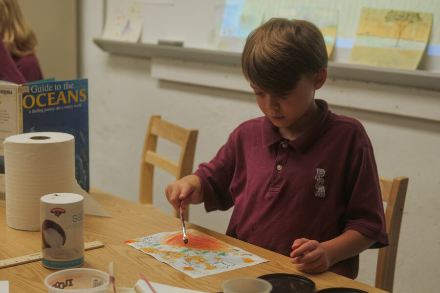 A Christian school boy wearing a maroon shirt.