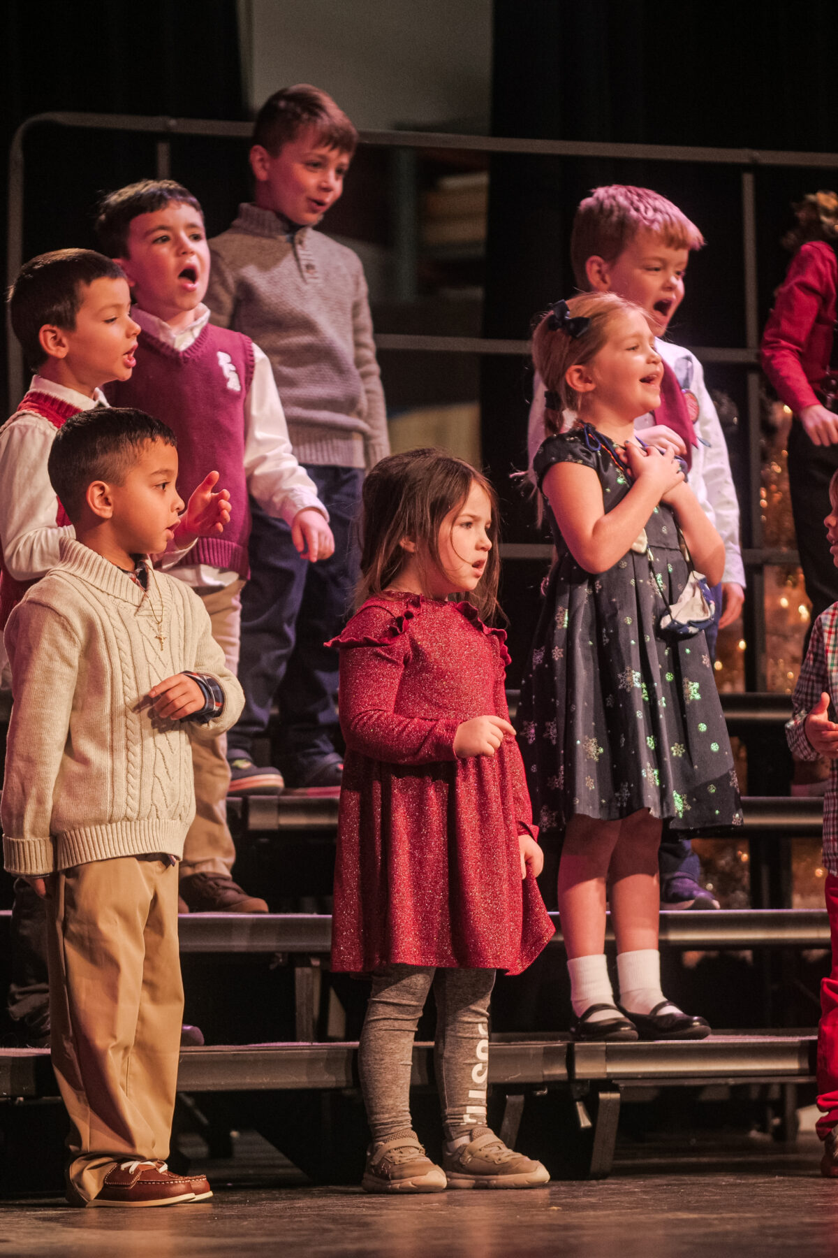 A group of children from a Christian school singing on a stage.
