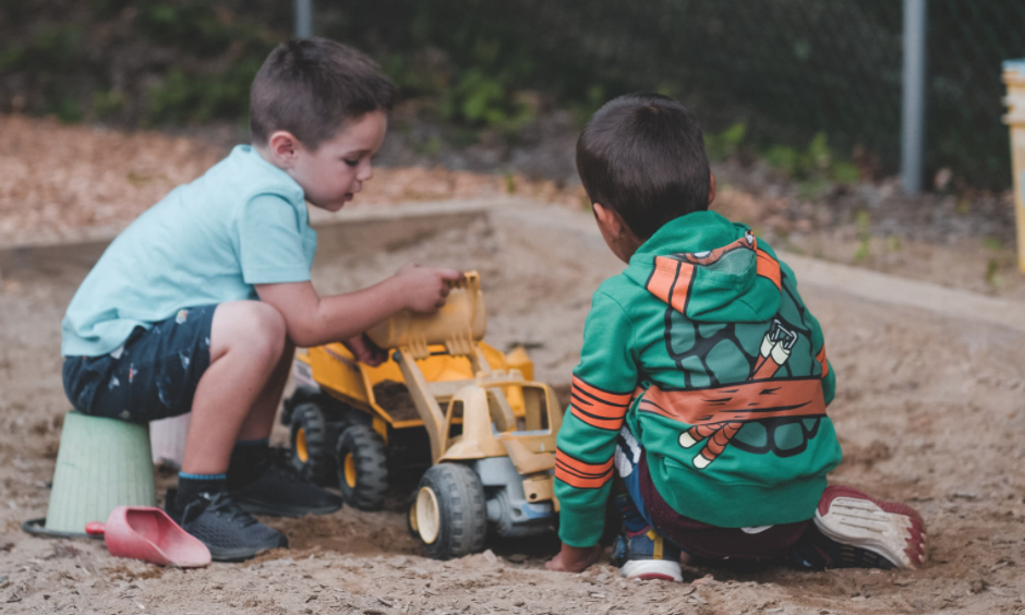 Two boys playing with a toy truck at a Christian school.