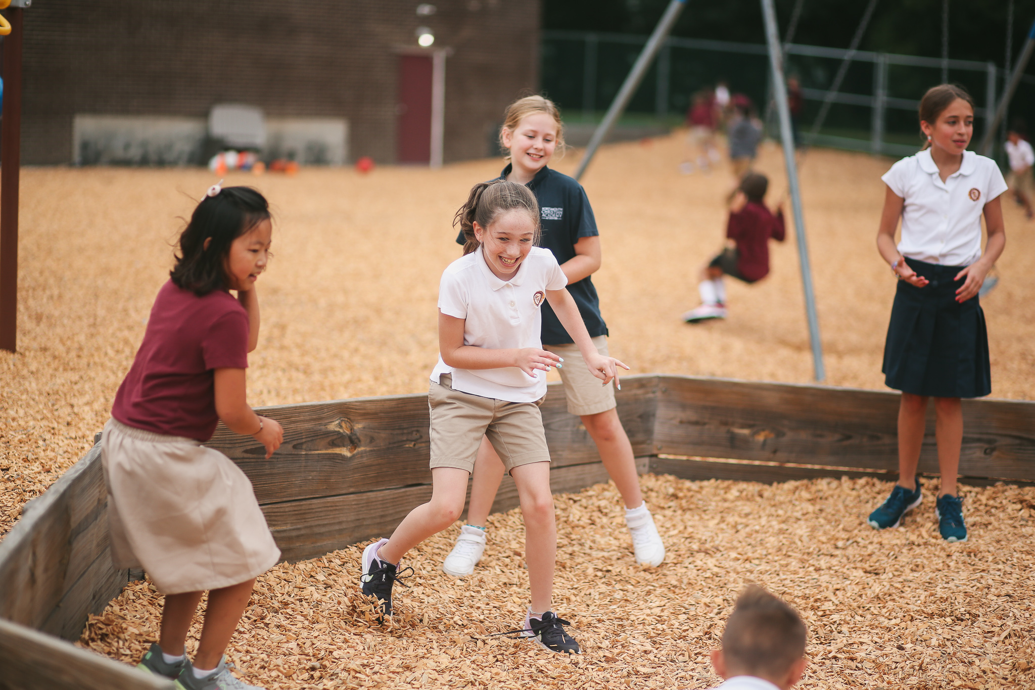 A group of young girls from a Christian school playing in a playground.