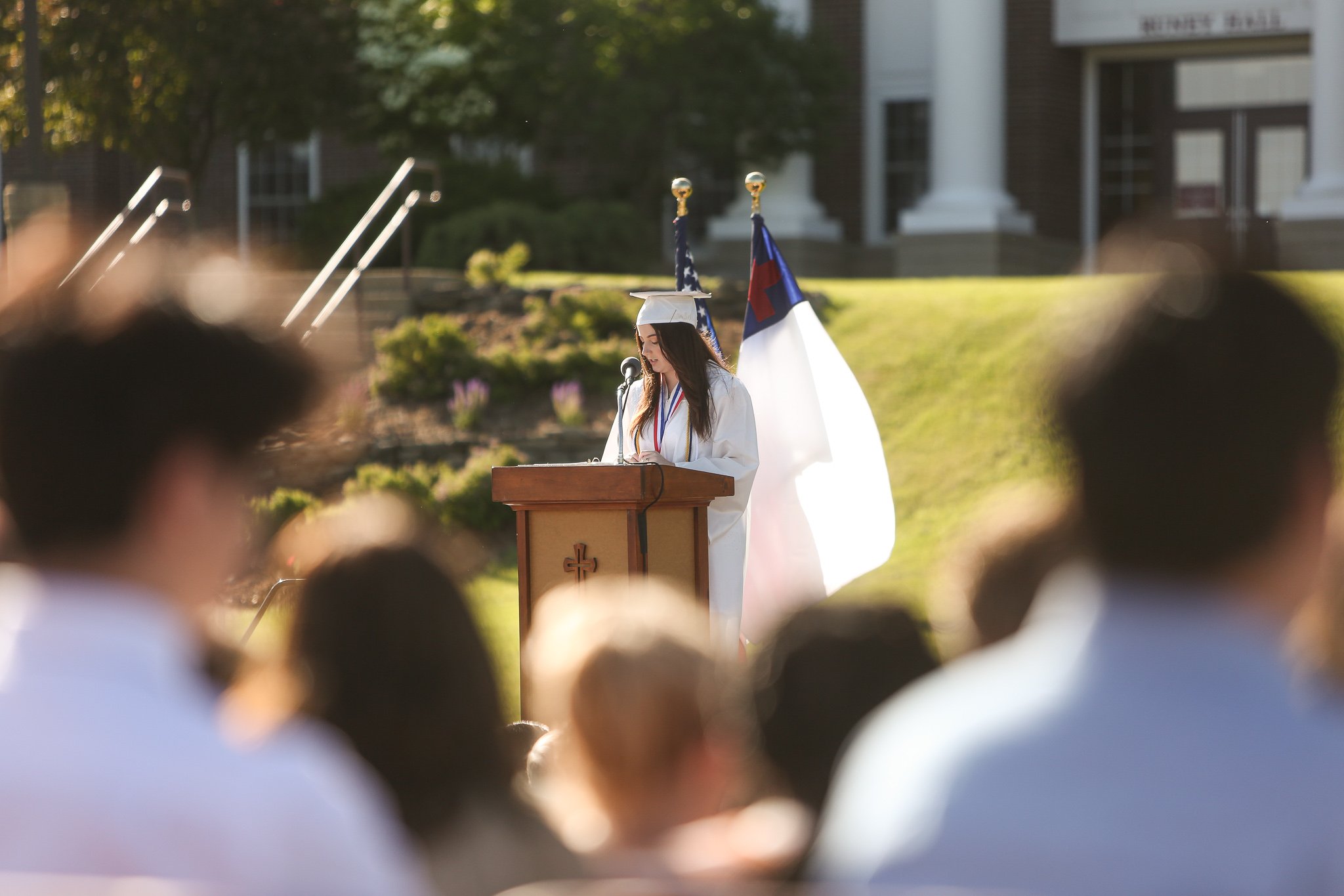 A group of people walking down a street in front of a red tent.