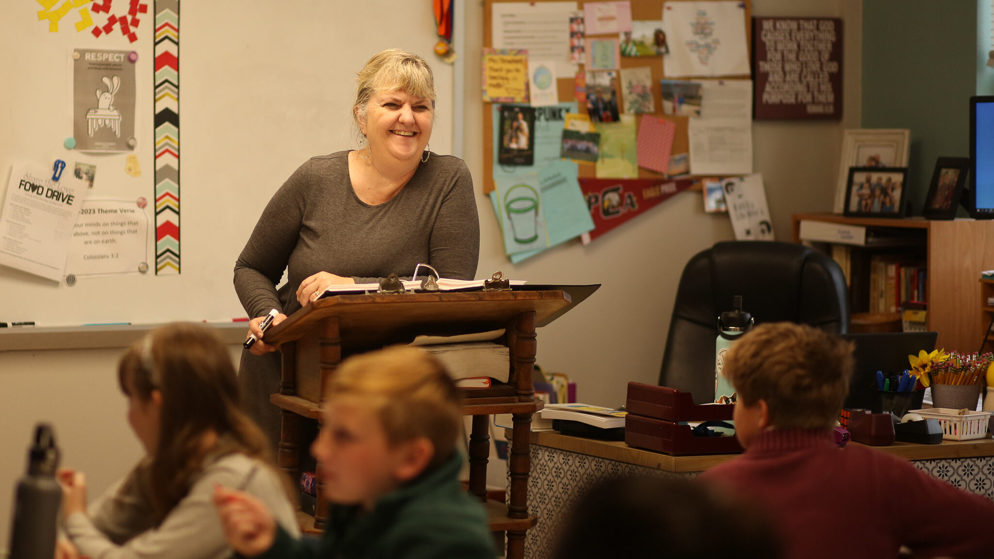 Middle school teacher smiles while teaching her class.