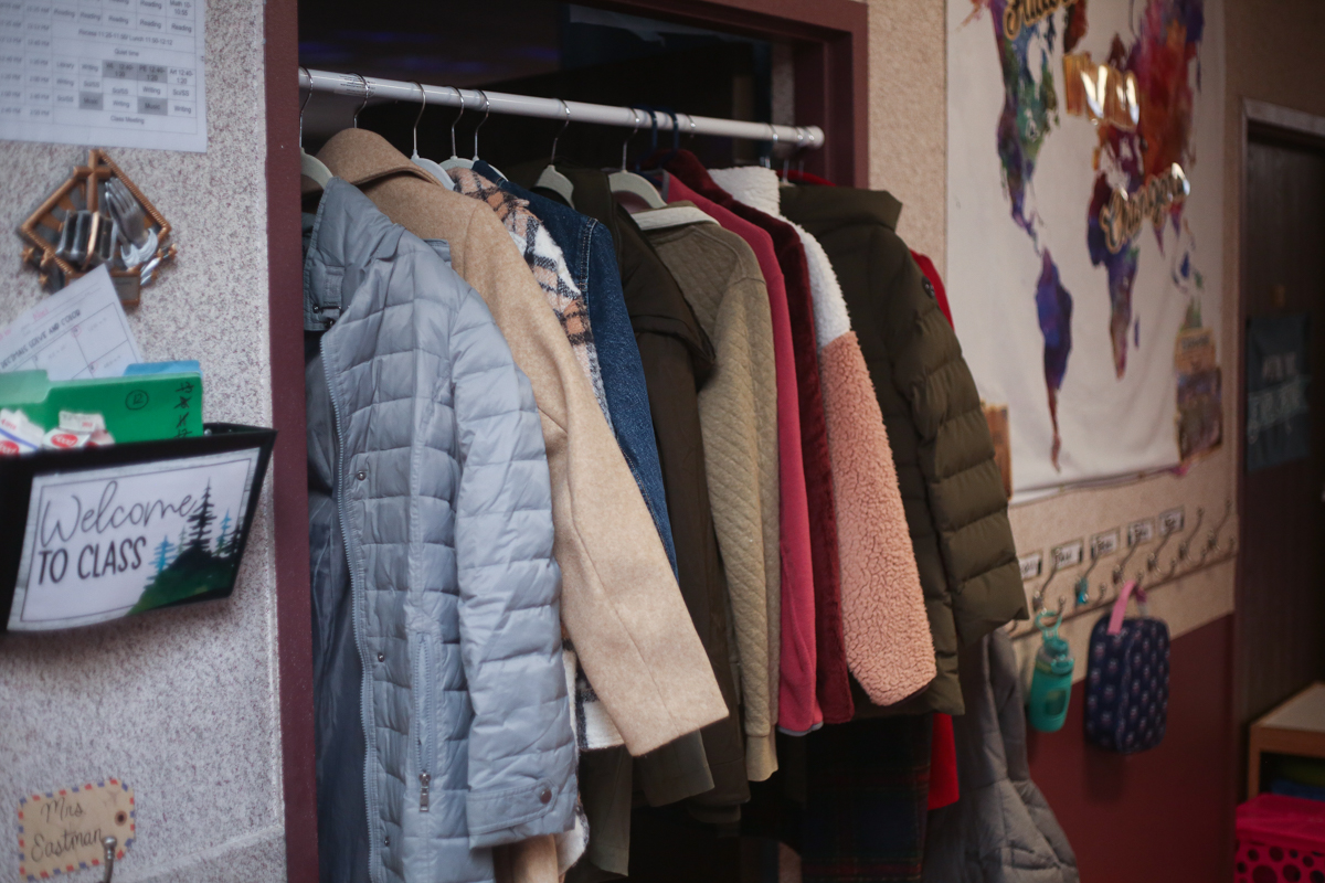 A closet with coats hanging on it.