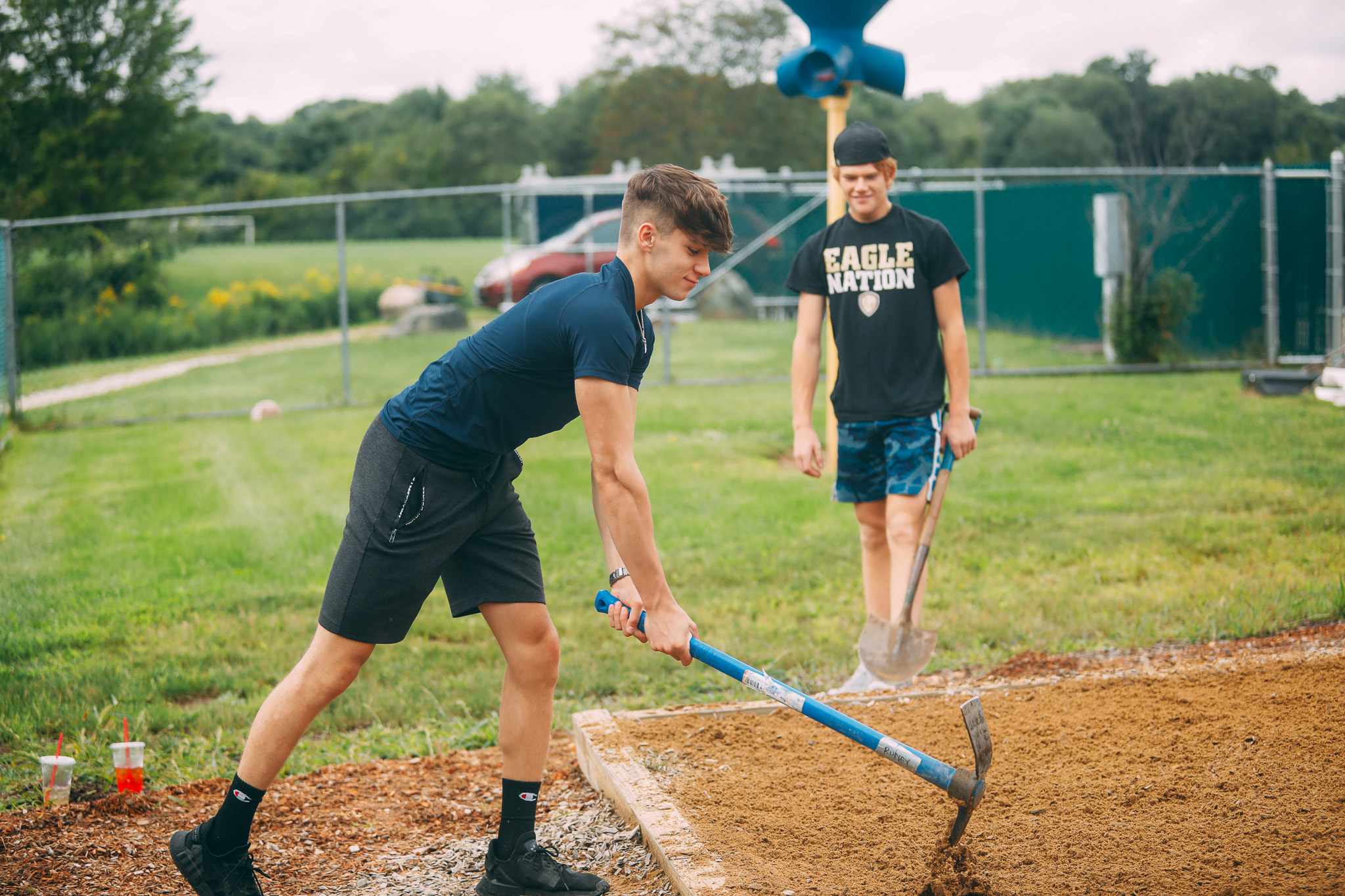 A group of people walking down a street in front of a red tent.